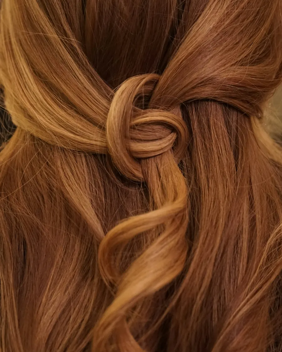 Langes kupferrotes Haar, halb hochgesteckt mit einem Knoten